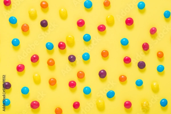 Fototapeta flat lay of colorful sprinkles over yellow background, festive decoration for banner, poster, flyer, card, postcard, cover, brochure, designers