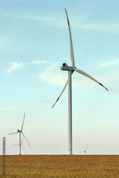 Fototapeta Wind energy. Wind power. Sustainable, renewable energy. Wind turbines generate electricity. Windmill farm on mountain with sunset sky. Green technology. Renewable resource. Sustainable development.