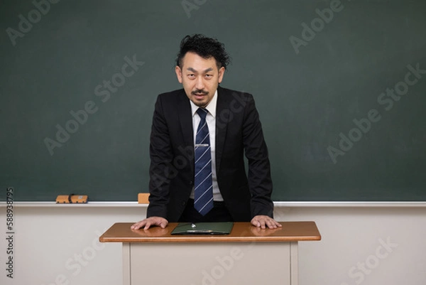 Fototapeta 教壇の黒板の前に立つ男性教師