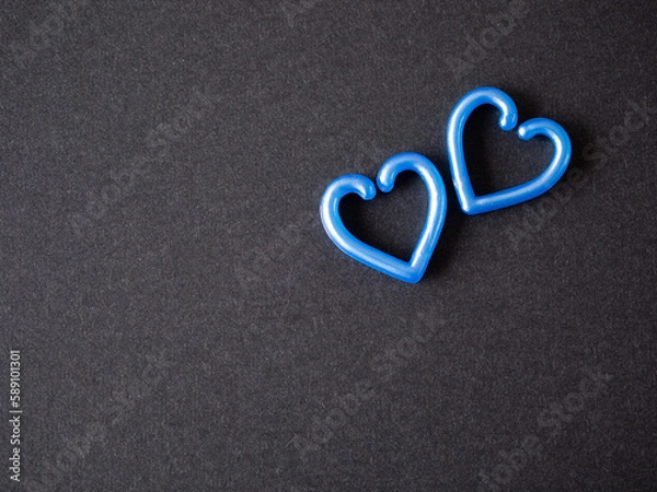 Fototapeta Two blue heart on the black paper background. top view, flat lay with copy space. Greeting card. .