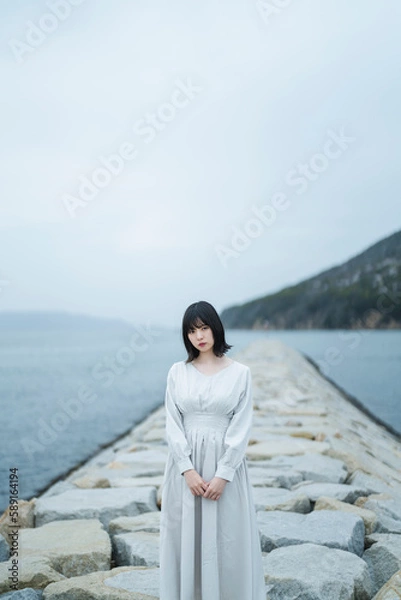 Fototapeta 夕暮れの海にいる女性