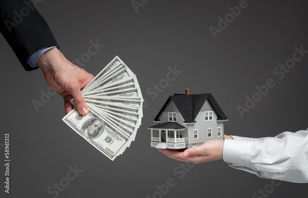 Obraz Close up of hands giving house model to other hands with money