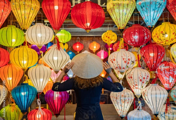 Obraz Back view anonymous woman in dress touching Asian conical hat on head while standing near colorful lanterns hanging on ceiling