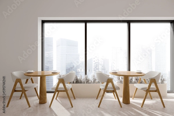 Fototapeta White cafe interior with two wooden tables and seats, panoramic window
