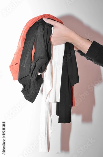 Fototapeta Woman's hands holding clothes on a white background
