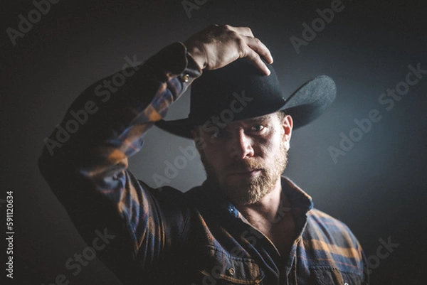 Fototapeta Rugged man in cowboy hat.  Studio session.