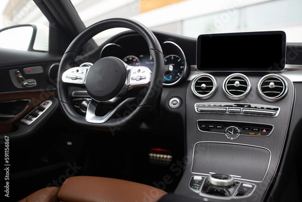 Fototapeta Modern luxury interior of car with leather seats big multimedia monitor dashboard and control panel view from rear seat row
