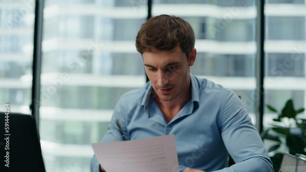 Obraz Excited man reading financial report sitting office close up. Manager rejoicing.