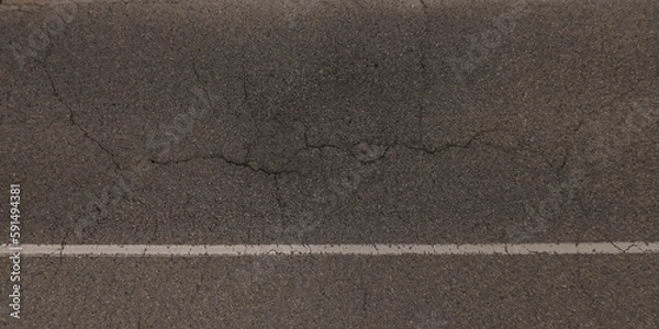 Fototapeta top view of surface of asphalt road made of small stones and sand with cracks