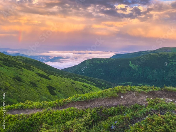 Fototapeta Rainbow and sunset clouds in Carpathian mountains. Ukraine