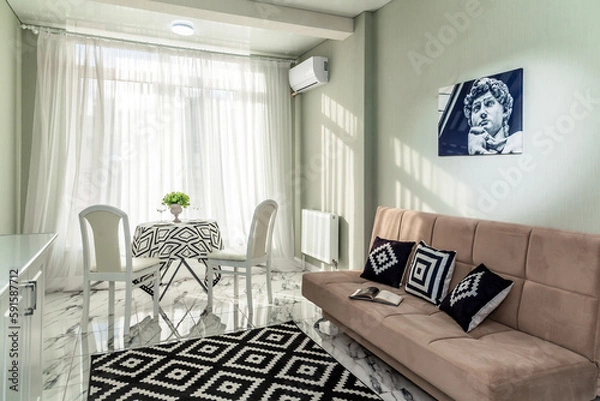 Fototapeta wide textile bright sofa with pillows and a blanket in a bright modern living room apartment interior