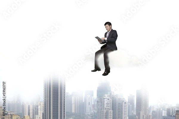 Fototapeta Businessman using tablet and sitting on cloud