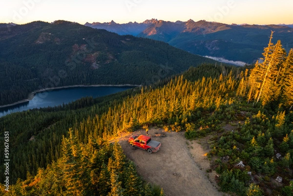 Fototapeta Drone shot of a pickup truck in front of volcanic mountain. Mount Rainier in the background. A perfect spot for camping off the grid.