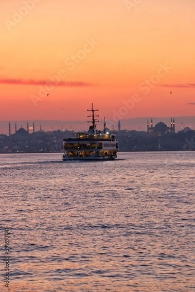 Fototapeta The ferry carrying the sunset and its passengers on the Bosphorus of Istanbul