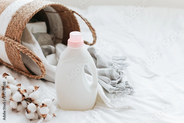 Fototapeta Washing gel liquid laundry detergent and fabric softener, basket with Peshtemal towel on white bed linen with copy space.
