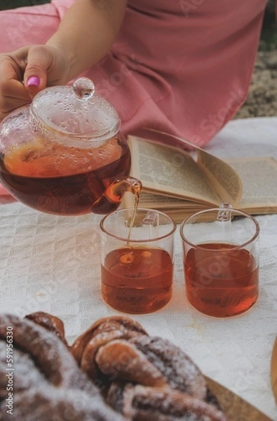 Obraz Picnic in spring under a tree in nature. A gourmet picnic in the park, laid out on a carpet around wine, cheese, fresh fruit, croissants.