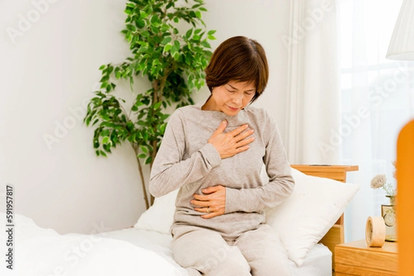 Obraz 自宅の個室で寝起きで胸とお腹が痛む50代から60代のシニアの女性