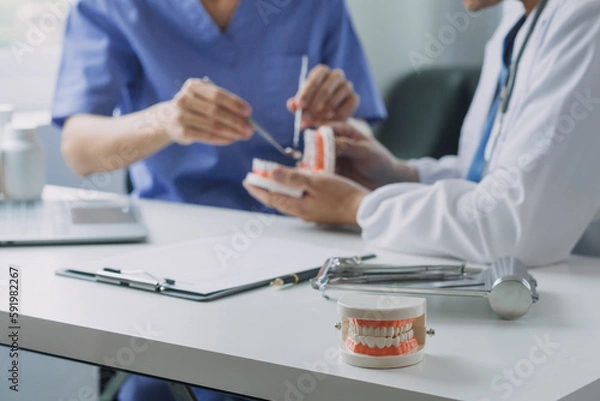 Fototapeta Dentists are discussing dental problems at report x-ray image on laptop screen to patients.