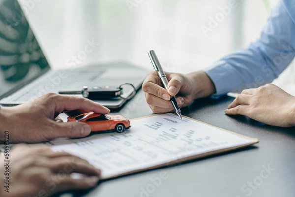 Obraz Salesman guiding customer seated at table. Car business. Car sale. Dealership closing. and the new owner has entered into a contract The idea of ​​selling and renting a car with insurance.