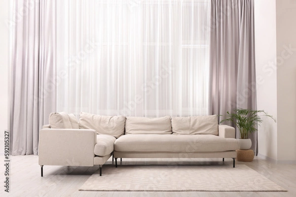 Fototapeta Comfortable sofa and window with beautiful curtains in room. Interior design