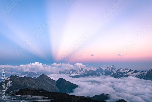 Fototapeta Anticrepuscular rays in the mountains, atmospheric optical phenomenon in the mountains above the clouds