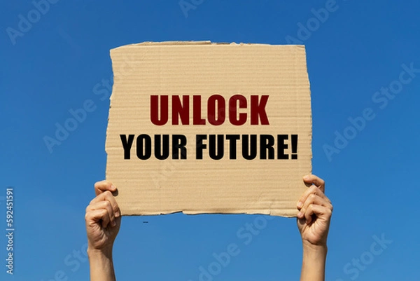 Fototapeta Unlock your future text on box paper held by 2 hands with isolated blue sky background. This message board can be used as business concept about your future.