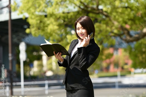 Obraz スマートフォンで電話するビジネスウーマン