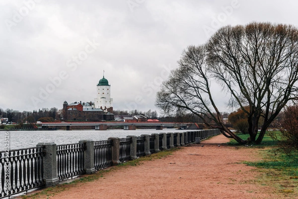 Fototapeta View of an empty embankment with a tree on the background of an island with an old medieval fortress.