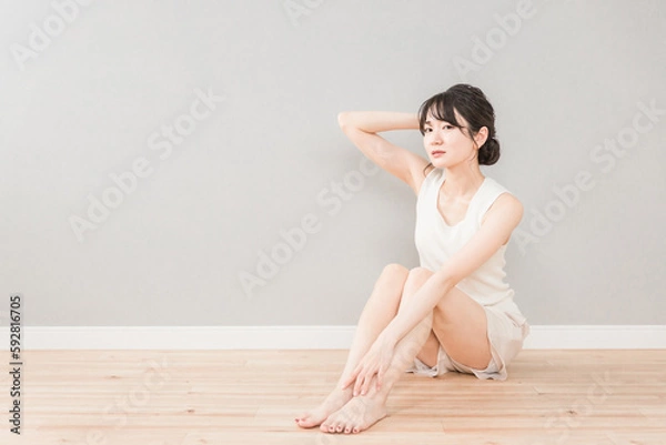 Obraz フローリングに座って考えごとをするアンニュイ表情のアジア人女性（脱毛・美容）
