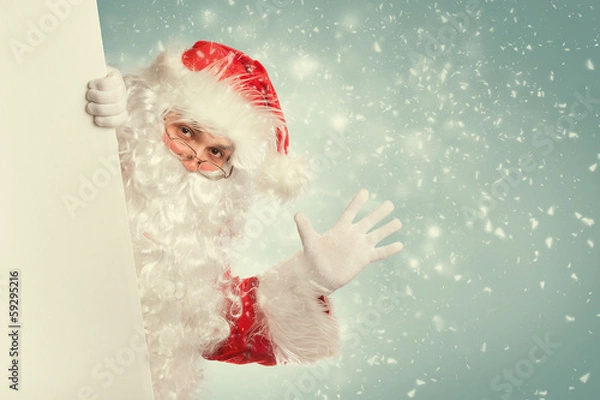 Fototapeta Santa Claus waving hello from behind white blank banner