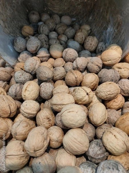 Fototapeta walnuts poured into a basket on the supermarket counter