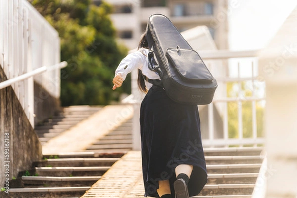 Fototapeta 階段を上る女性　楽器ケース　走る　