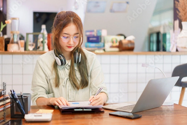 Fototapeta Coworking space office concept, Woman entrepreneur writing data and reading business document