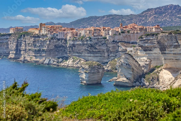 Obraz Bonifacio at the edge of the chalk cliffs. Bonifacio is situated on the cliffs of a limestone peninsula sculpted and eroded by the sea, with buildings overhanging the edge, Corsica island, France
