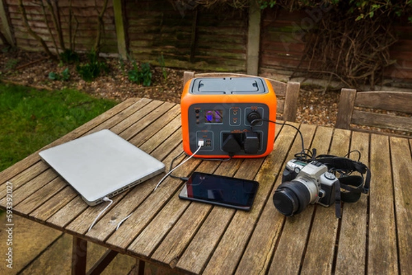 Fototapeta Portable power station solar electricity generator with laptop, tablet and camera charging. 