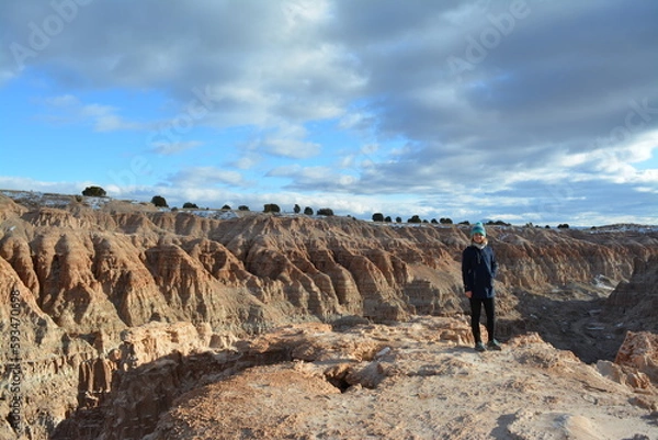 Fototapeta woman in the Cathedral Gorge State Park on a cold day in December, located in a long, narrow valley in southeastern Nevada, where erosion has carved patterns in bentonite clay