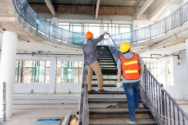 Fototapeta Construction concept of Engineer and Architect working with construction model and blueprint at construction site, Engineer and Architect discussing construction plan at building site