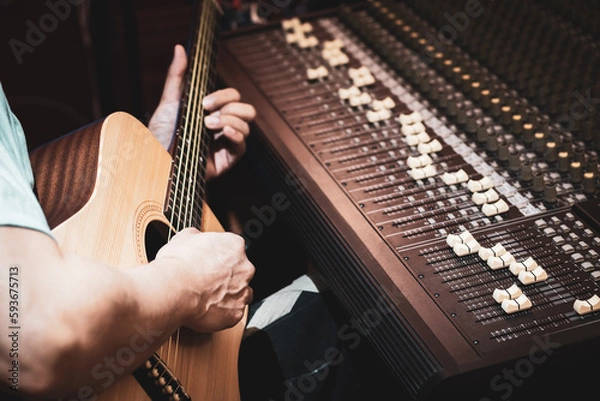 Obraz close up male musician, composer playing acoustic guitar in studio. acoustic musical instrument recording or songwriting concept