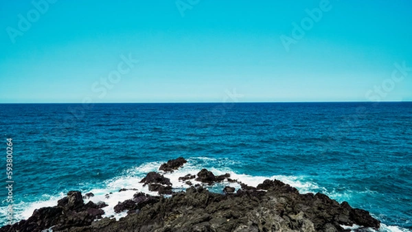 Obraz Blue sky and summer sea with rocky wave foam