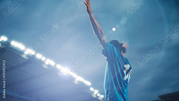 Fototapeta Football Match Championship: Portrait of Soccer Player Standing, Posing, Smiling, Raising Hands to Cheer. Professional Hispanic Footballer, Champion Ready to Win Tournament. Medium Shot