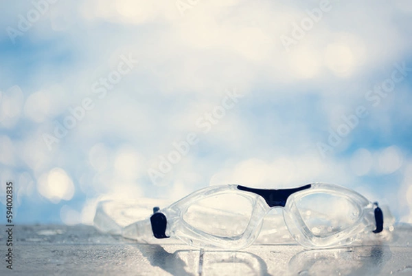 Obraz Close-up shot of swimming goggles on swimming pool, text input background in swimming pool.