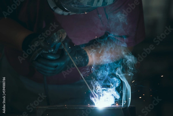 Obraz Industry worker welding iron pieces at work