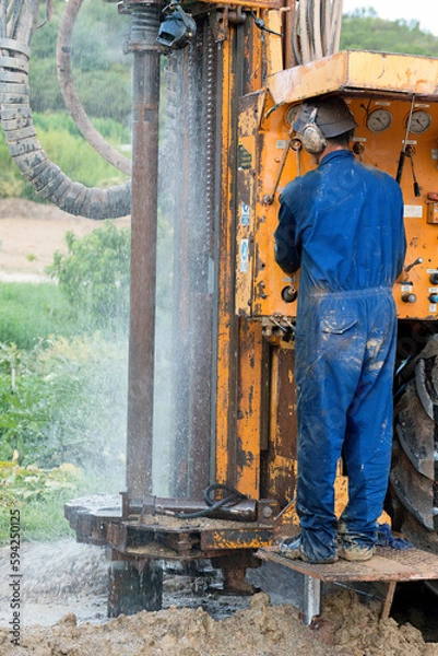 Fototapeta Hope in the Depths: Capturing the Journey of a Water-Seeking Machine in Times of Drought