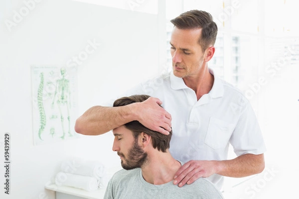 Obraz Male chiropractor doing neck adjustment