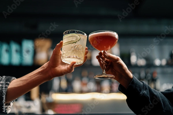 Fototapeta Close up of two people cheering cocktails in a bar or disco club drinks and cocktails concept
