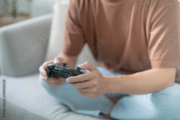 Obraz Young Asian man gamer controller video console playing holding hobby playful Online Video Game enjoyment eSport Cyber Games Internet.