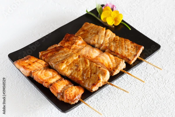Obraz Assortiment de brochettes yakitori: brochette de poulet, brochette de boeuf fromage, brochette de saumon sur une assiette noir et fond blanc. Cuisine japonaise.