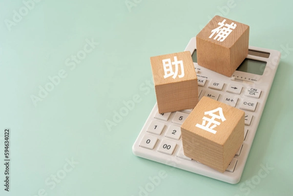 Obraz 補助金と書かれたブロックと電卓