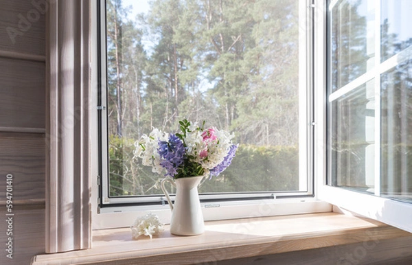 Fototapeta White window with a mosquito net in a rustic wooden house. Spring bouquet of hyacinths on the windowsill