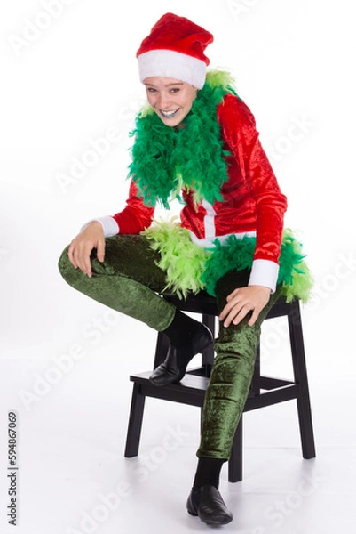 Obraz Young girl wearing red santa clause hat like a grinch hand on hip laughing. Concept for humor and happy Christmas. Isolated on white background. Negative human emotions